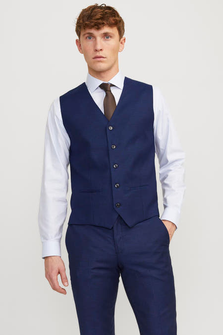 Gilet bleu de PREMIUM par JACK & JONES, vu de l'arrière, combiné avec une chemise blanche et un pantalon bleu marine.