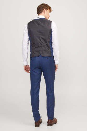 Blauw gilet van PREMIUM by JACK & JONES, rugzijde met verstelbare riem, gecombineerd met een wit overhemd en blauwe pantalon.