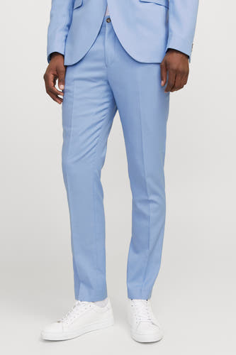 Pantalon de costume bleu clair de PREMIUM by JACK & JONES, avec des plis et des baskets blanches.