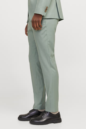 Pantalon de costume vert de PREMIMI by by & JONES, avec des chaussures noires et des chaussettes en vue latérale.