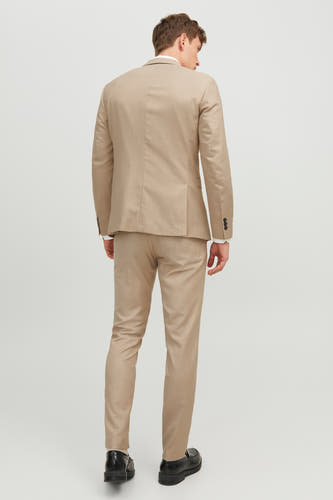 Beige kostuumbroek van PREMIUM by JACK & JONES, gezien van achteren, met zwarte schoenen.

