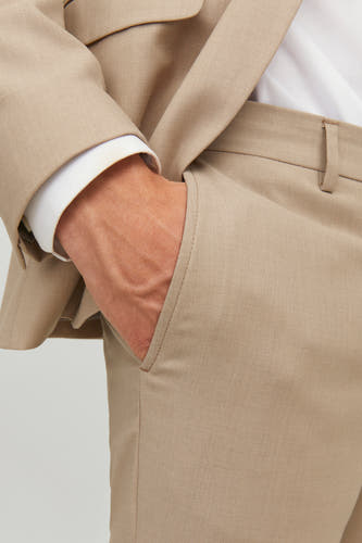 Pantalon de costume beige de PREMIUM by JACK & JONES, avec une main dans la poche et un motif uni.