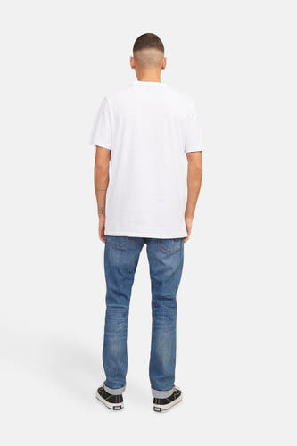 Middenblauwe slim fit jeans van JACK & JONES JEANS INTELLIGENCE, gedragen met een wit T-shirt en zwarte schoenen, achteraanzicht.