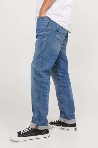 Jean slim bleu de JACK & JONES, avec des poches rabattues et des chaussures en toile noire.