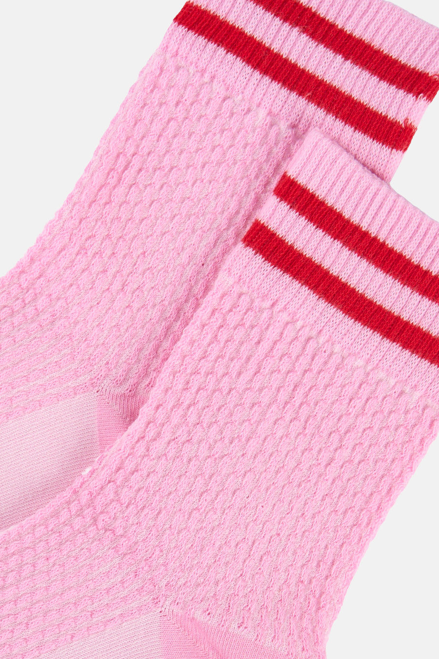 Roze sokken met rode strepen van BIRDLAND, getextureerd gebreid in close-up.
