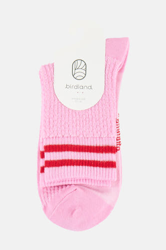 Chaussettes roses BIRDLAND avec une texture tricotée, deux rayures rouges et une étiquette blanche.