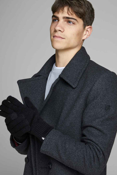 Homme avec des gants noirs et une veste en laine grise.