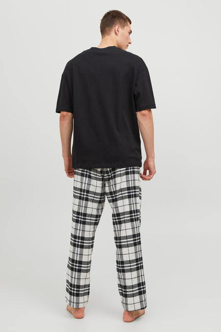 Pantalon de pyjama noir et blanc d'ACCESSORIES BY JACK & JONES, à motif à carreaux, porté avec un t-shirt noir.