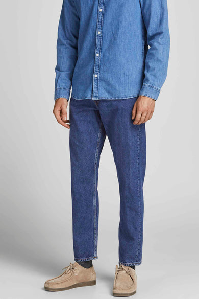 Boutons de fermeture éclair sur des jeans en cours de JACK & JONESONESONES JEANS INTELLIGENCE, avec une lavage denim bleu moyen et des chaussures en cuir suédé.