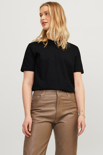 T-shirt noir de JJXX, porté avec un pantalon en cuir marron et une bague en argent.