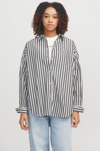 Chemise rayée blanche et bleue à manches longues de JJXX, portée sur un T-shirt blanc et des jeans denim légers.