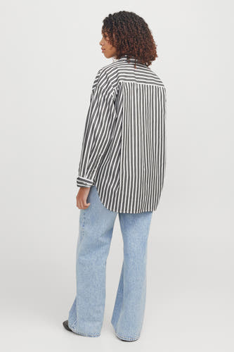 Chemise blanche à manches longues de JJXX, avec un motif rayé et portée avec des jeans bleus.