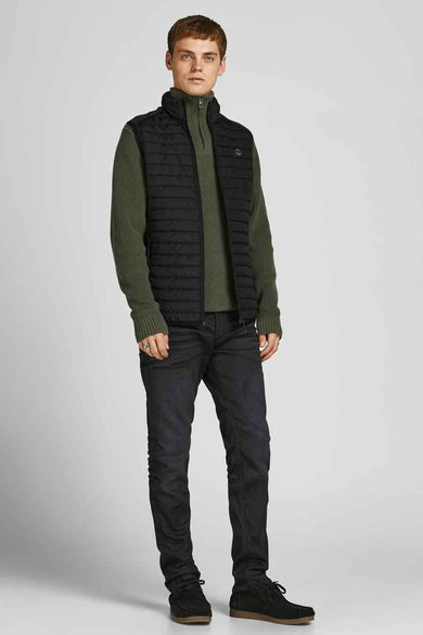 Gilet bodywarmer noir de CORE BY JACK & JONES, porté sur une chemise verte avec des jeans foncés et des chaussures.