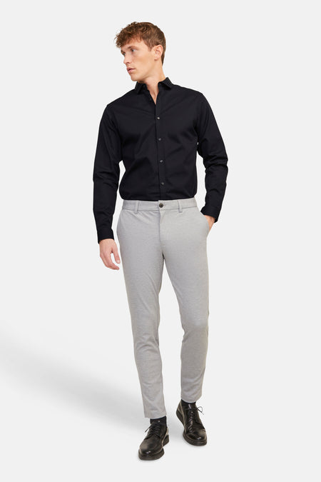 Zwart hemd van PREMIUM by JACK & JONES, met lange mouwen, gedragen met grijze broek en zwarte schoenen.