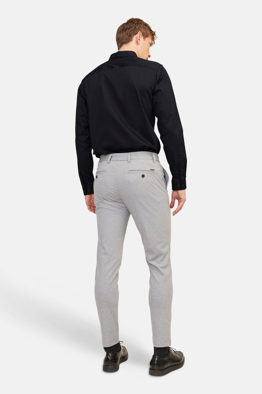 Chemise noire (manches longues) de PREMIUM by JACK & JONES, dos, combinée avec un pantalon gris et des chaussures noires.