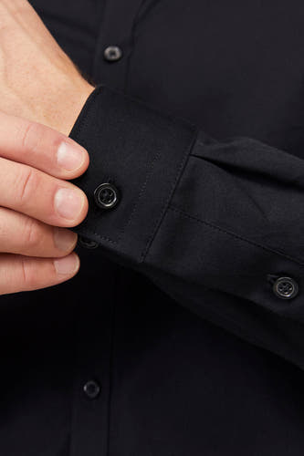 Chemise noire à manches longues de PREMIUM by JACK & JONES, gros plan sur le poignet et la patte de boutonnage.