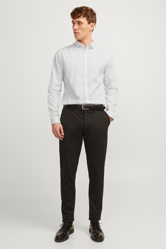 Chemise blanche à manches longues de PREMIUM by JACK & JONES, portée avec un pantalon noir, une ceinture et des chaussures.