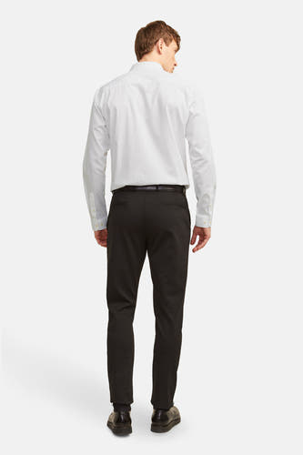 Chemise blanche à manches longues de PREMIUM by JACK & JONES, vue de derrière avec un pantalon noir et une ceinture.
