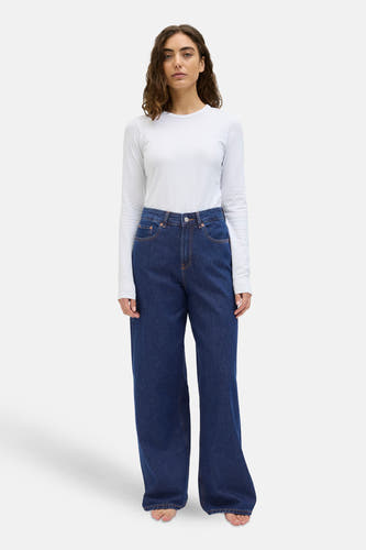 Jean en denim bleu foncé de JJXX, associé à une chemise blanche à manches longues.
