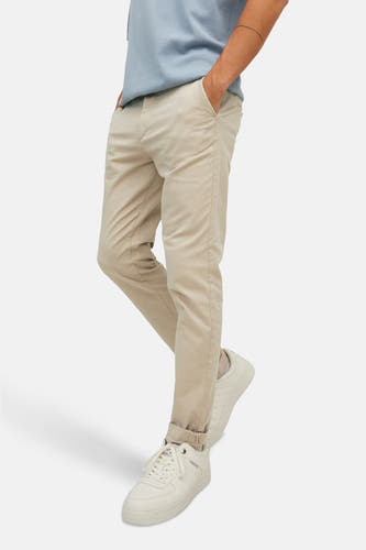 Beige chino van JACK & JONES JEANS INTELLIGENCE, met opgerolde pijpen en bijpassende sneakers.
