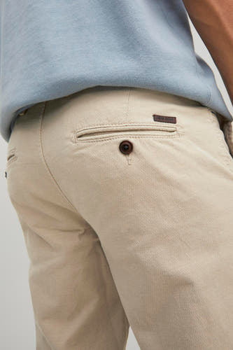 Chino beige de JACK & JONES JEANS INTELLIGENCE, avec une poche à boutons et une texture subtile.