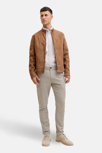 Man in bruine jas en beige broek.