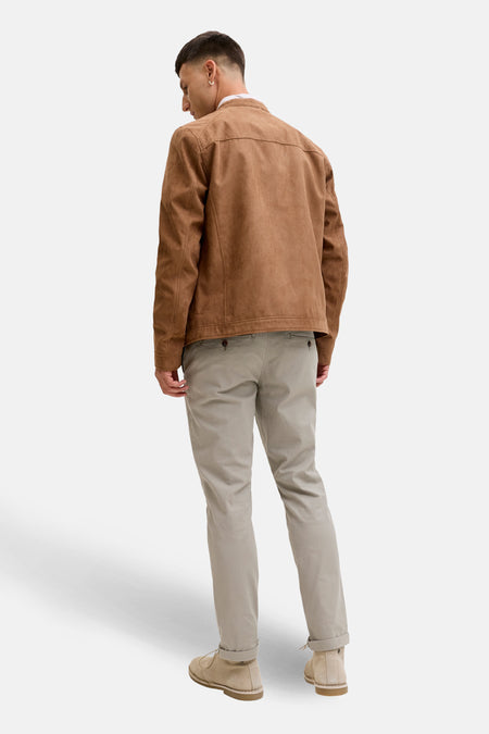 Man van achter, bruin jasje, beige broek, suede schoenen.
