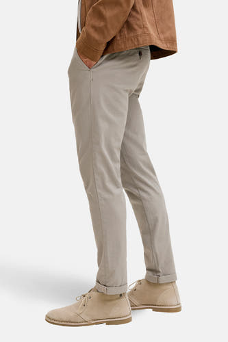 Jean chino vert de JACK & JONES JEANS INTELLIGENCE, avec poche et jambes repliées, associé à des chaussures en cuir marron et en suède.