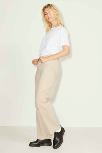 Jean droit beige de JJXX, avec un t-shirt blanc et des chaussures noires.