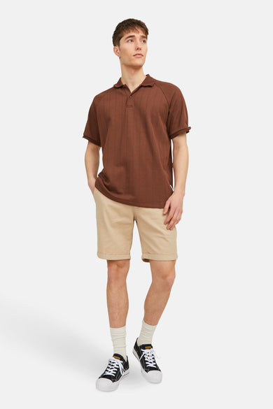 Short beige de JACK & JONES JEANS INTELLIGENCE, combiné avec un polo marron, des chaussettes blanches et des baskets noires.