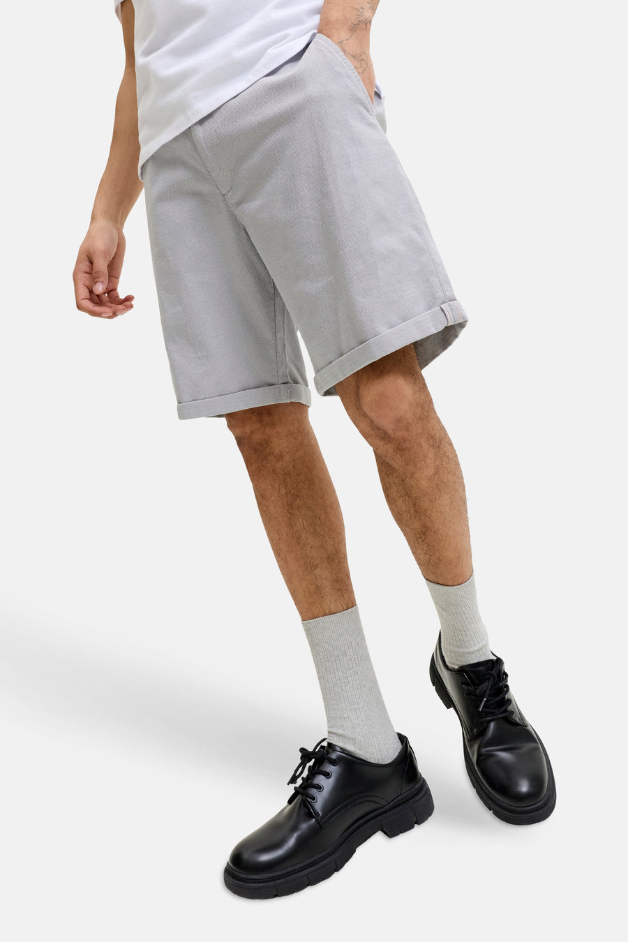 Short gris de JACK & JONES JEANS INTELLIGENCE en tissu structuré avec revers, porté avec des chaussettes grises et des chaussures noires.