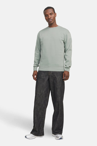 Pull-over vert de rond collet de CORE BY JACK & JONES, porté avec un pantalon foncé et des baskets.