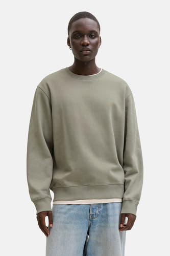 Gilet kaki avec col rond de CORE BY JACK & JONES, porté sur un t-shirt blanc et des jeans bleus.