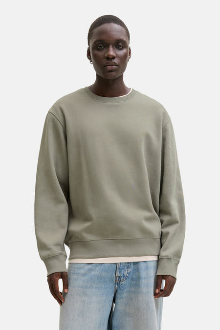Gilet kaki avec col rond de CORE BY JACK & JONES, porté sur un t-shirt blanc et des jeans bleus.
