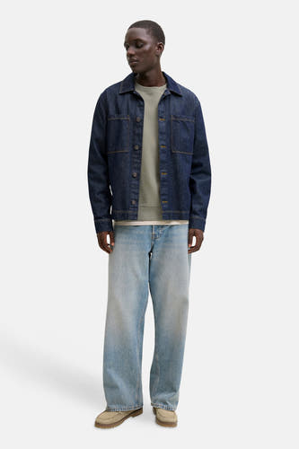 Gilet kaki avec col rond de CORE BY JACK & JONES, porté sous un blouson en denim et des jeans larges.