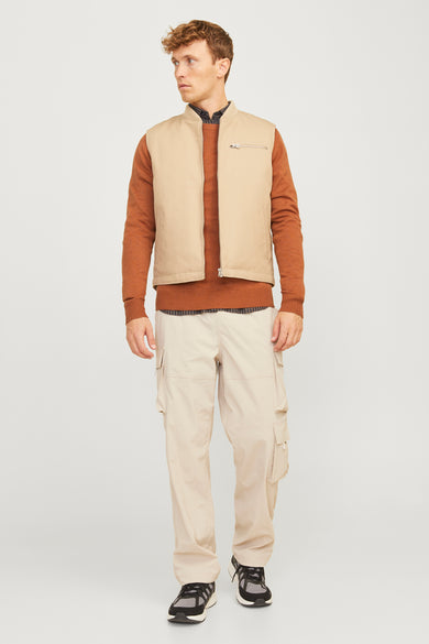 Pull-over marron avec col rond de PREMIUM BLUE par JACK & JONES, porté sous un gilet beige et un pantalon cargo.