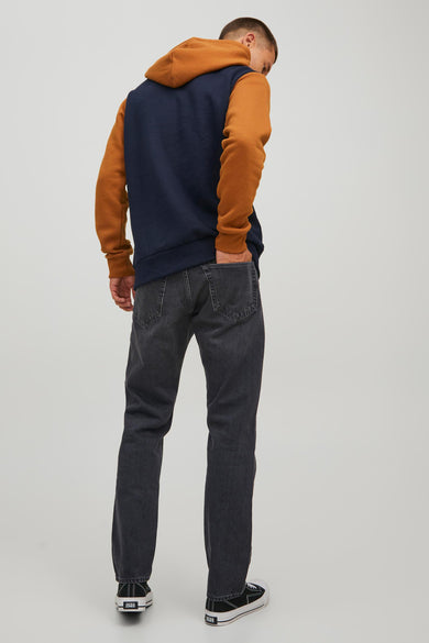 Donkergrijze tapered jeans van JACK & JONES JEANS INTELLIGENCE, met achterzakken en zwarte sneakers.
