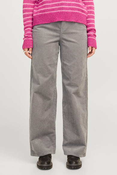 Pantalon de corduroy gris de JJXX, avec une jambe large et associé à un pull rayé rose.