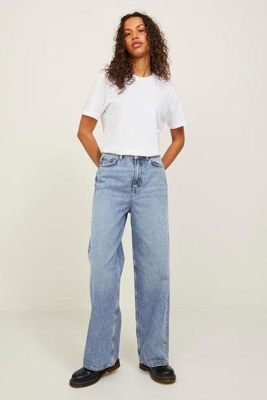 Jean large de JJXX, en denim bleu moyen, combiné avec un t-shirt blanc et des chaussures noires.