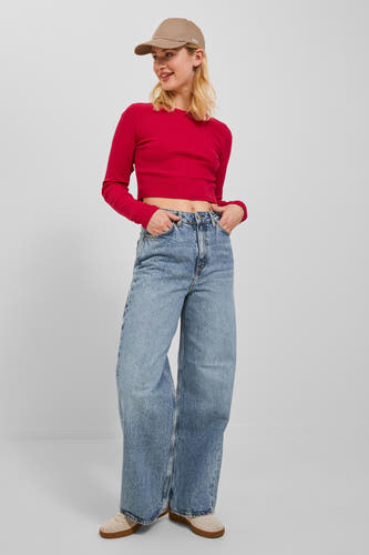 Jean large denim bleu moyen de JJXX, combiné avec un haut rouge et un chapeau beige.