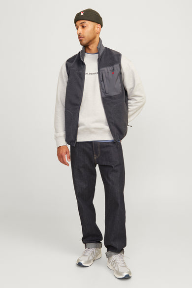 Grijze bodywarmer van Royal Denim Division, met sherpa textuur en een grijze trui, donkere jeans en zilveren sneakers.