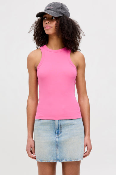 T-shirt rose sans manches de JJXX, associé à une jupe en denim et un chapeau.