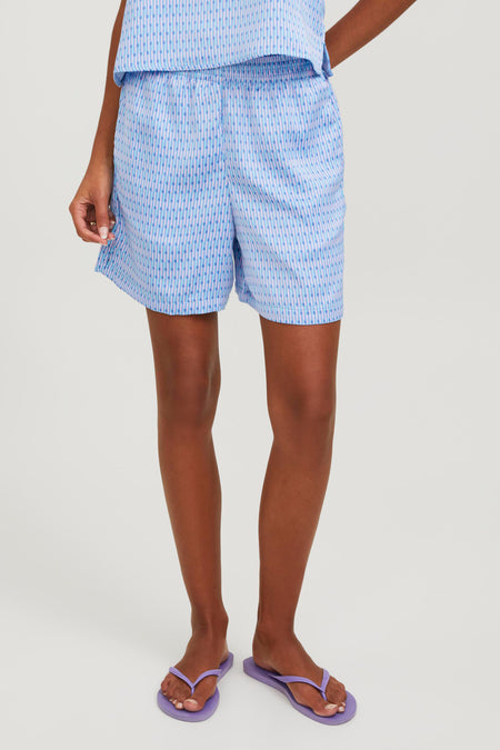 Short bleu de JJXX avec un motif à rayures verticales porté avec des chaussettes rouges.