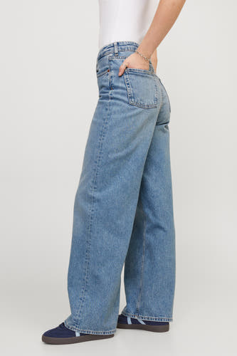 Blauw denim JXTOKYO wide jeans van JJXX, met brede pijpen en een hand in de zak.
