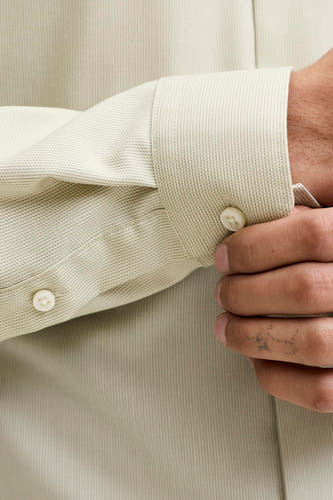 Chemise verte à manches longues de PREMIUM by JACK & JONES, avec une fine texture et un détail de bouton sur la manche.