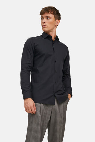 Chemise noire à manches longues de PREMIUM by JACK & JONES, avec un homme qui boutonne ses manchettes.