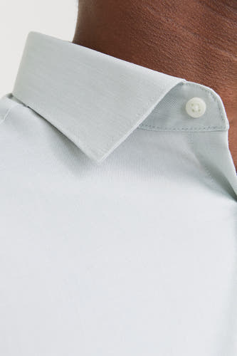 Chemise verte à manches longues de PREMIUM by JACK & JONES, gros plan du col et d'un bouton.