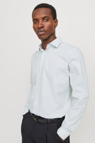 Chemise verte à manches longues de PREMIUM by JACK & JONES, avec pantalon noir et ceinture.