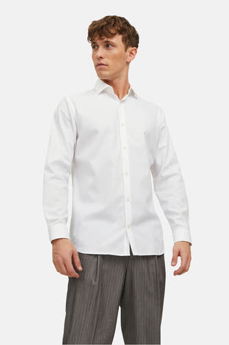 Chemise blanche à manches longues de PREMIUM by JACK & JONES, portée avec un pantalon rayé.