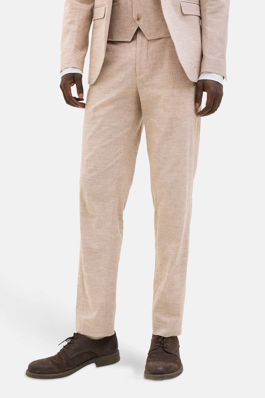 Beige linnen pak met bruine schoenen.
